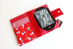 a cell phone is in the pocket of a red wallet with white polka dots on it