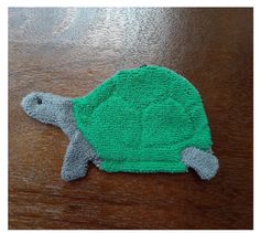 a knitted turtle hat sitting on top of a wooden table