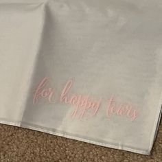 a white table cloth with the words for happy tears written on it and pink lettering