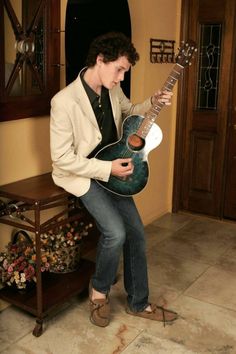 a young man is playing an electric guitar