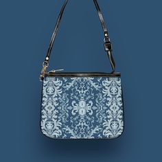 This unique and vibrant shoulder bag adds a chic touch to any outfit. Its compact size (10"w x 8"h) and lightweight construction makes it the perfect accessory for carrying around your essentials in style. Our one of a kind purse features an archival fabric design in baroque flourishes of sapphire, sky and pale blues. This gorgeous design is printed onto high-grade vegan leather and shipped to you by our top-rated production partner. We also offer the coordinating vegan wallet: https://thecheekyshedonist.etsy.com/listing/1680599038 .: 100% high-grade vegan leather exterior .: Polyester lining + 20-inch black strap .: Two open pockets inside .: Gold-toned zipper and hardware .: Original + unique art history design exclusively available at The Cheeky Shedonist  Care instructions: avoid prolo Daily Use Shoulder Bag Pouch, Shoulder Bag With Removable Pouch Shaped As Clutch, Trendy Rectangular Shoulder Bag With Zipper Pouch, Trendy Shoulder Bag With Zipper Pouch For Daily Use, Elegant Zipper Pouch Bag For On-the-go, Trendy Pouch Evening Bag For Daily Use, Trendy Zipper Pouch Shoulder Bag, Trendy Satchel Shoulder Bag With Zipper Pouch, Trendy Shoulder Bag With Zipper Pouch