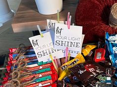 a table topped with lots of candies and signs that say let your light shine shining