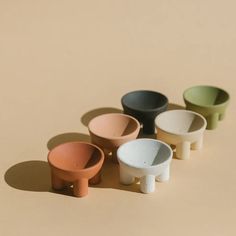 five small bowls sitting on top of each other in different colors and sizes, all with one bowl at the bottom