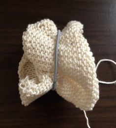 a white knitted bow sitting on top of a wooden table