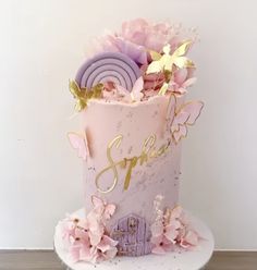 a pink and gold birthday cake decorated with flowers