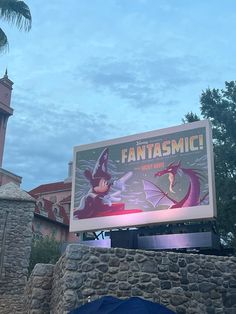 a sign that says fantassmic on it in front of a building with a clock tower