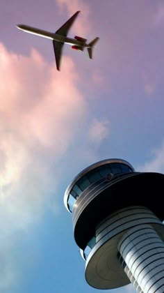 an airplane is flying in the sky near a tower