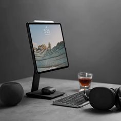 a computer monitor sitting on top of a desk next to headphones and a keyboard