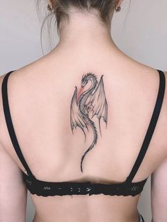 a woman with a dragon tattoo on her back