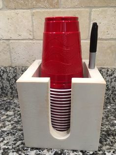 a red cup sitting inside of a white holder