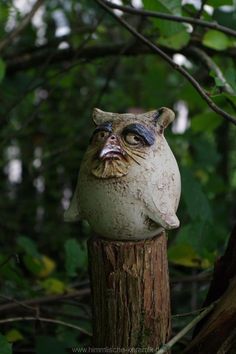 a statue of an owl on top of a tree stump