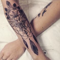 a woman's arm with an arrow and flower tattoo on the left side of her leg