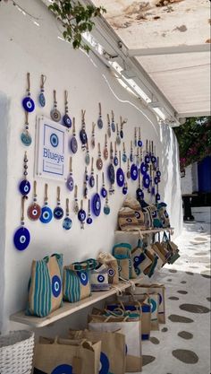 bags and purses are on display in front of a white wall with blue circles