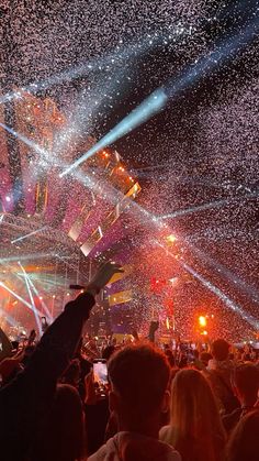 people are standing in the middle of a concert with confetti all over them