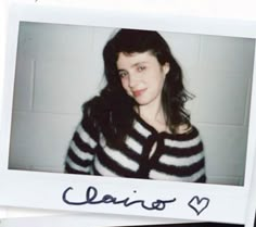 a polaroid photo of a woman wearing a black and white striped cardigan with the word ciario written on it