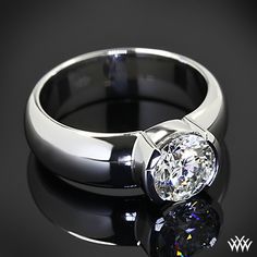 a close up of a ring with a diamond on it's center and reflection in the ground