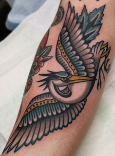 a close up of a person's arm with a bird tattoo design on it