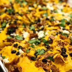 a casserole dish with meat, cheese and black olives