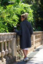 a woman standing on a bridge looking at something in her hand as she looks over the railing