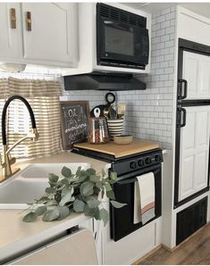 a kitchen with white cabinets and black appliances