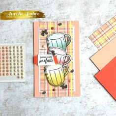 a card with two mugs on it next to a rubber stamp and some papers