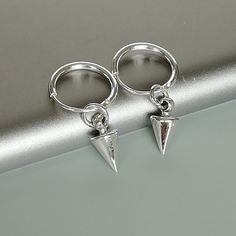 A PAIR of sterling silver hoops. Comes with a detachable spike charm. The charm is multipurpose and can be used with a neck or bracelet chain too. Dimension: Hoop- 1.2 x 12 mm Spike charm: 5 x 9 mm Weight: 1.6 gm Price is for ONE PAIR. These earrings are made of 925 hypoallergenic sterling silver. Most of my pieces come with a 925 stamp. Can be packaged in a gift box. I can include a personal message from you if needed You are welcome to contact me at... bhavnakwintra1956@gmail.com For more beau Nickel-free Silver Dangle Huggie Earrings, Silver Dangle Huggie Earrings Nickel-free, Silver Nickel-free Dangle Huggie Earrings, Silver Huggie Earrings With Charms, Silver Dangle Hoop Earrings With Charms, Minimalist Sterling Silver Hoop Earrings With Dangling Charms, Silver Minimalist Huggie Dangle Earrings, Trendy Sterling Silver Dangle Huggie Earrings, Minimalist Silver Dangle Huggie Earrings