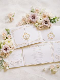 the wedding stationery is laid out on top of the table with flowers and greenery