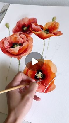 someone is painting flowers with watercolors on paper