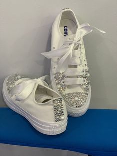 pair of white shoes with bows and crystals on them