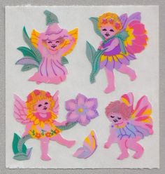 four stickers with pink and yellow tinkerbells, one is holding a flower