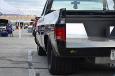 the back end of a pickup truck parked in a parking lot next to other cars