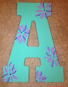 the letter a is painted with flowers and has blue paint on it's sides