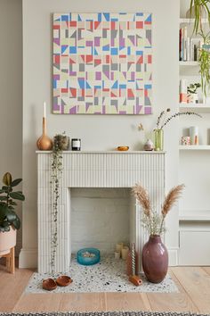 a living room filled with furniture and a painting on the wall above a fire place