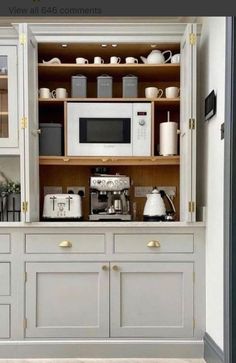 a white microwave oven sitting inside of a kitchen cabinet next to a coffee maker and toaster