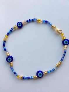 Evil eye protection bracelet with flat evil eye protection glass beads and gold and blue mix seed beads. Finished with gold tone lobster clasp. Choose your length Blue Beaded Bracelets With Gold Beads For Beach, Handmade Blue Evil Eye Bracelet With Round Beads, Blue Heishi Beads Bracelet With Gold Accents, Blue Heishi Beads Bracelet With Gold Beads, Blue Beaded Necklaces With Lobster Clasp For Festival, Blue Beaded Necklace For Festival With Lobster Clasp, Blue Beaded Evil Eye Bracelets For The Beach, Blue Evil Eye Beaded Bracelets For Beach, Blue Evil Eye Bracelet With Tiny Beads For Gift