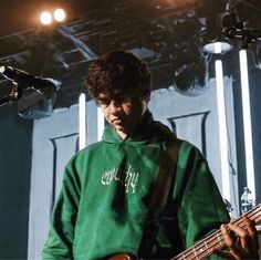 a young man playing a bass guitar on stage