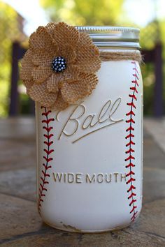 a white mason jar with a brown flower on the lid that says, ball wide mouth