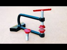 a pair of red and black screws on top of a metal stand with two bolts