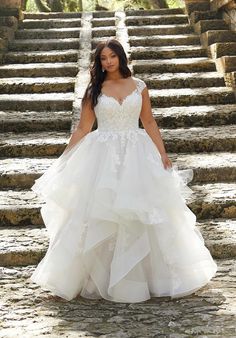 a woman in a wedding dress standing on some steps