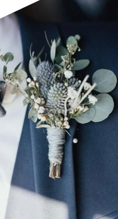 a boutonniere with flowers and greenery on it's lapel