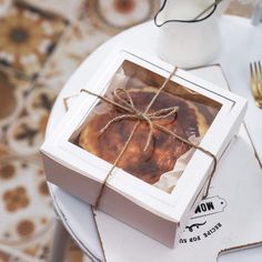 a box with some kind of pastry wrapped in twine on top of a table