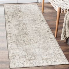 a white rug with an old fashion design on the floor next to a wicker chair