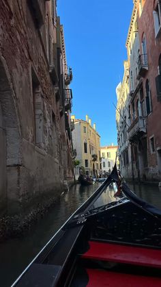 a boat traveling down a river next to tall buildings on either side of the water