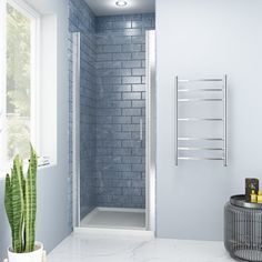 a white bathroom with blue walls and tile flooring, along with a plant in the corner