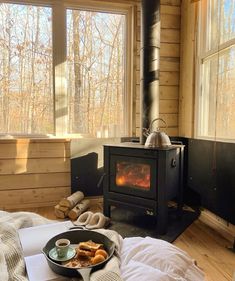 a bed room with a plate of food on the bed and a stove in the corner