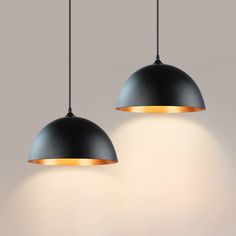 two black pendant lights hanging from a ceiling