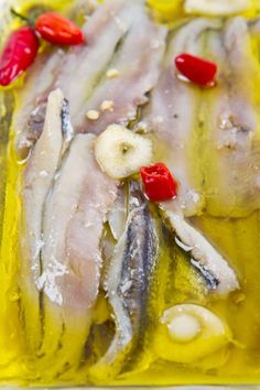 an image of fish in oil with peppers on the side