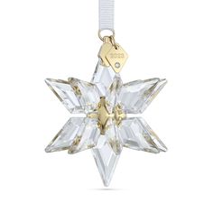 an ornament shaped like a snowflake with a gold plated charm