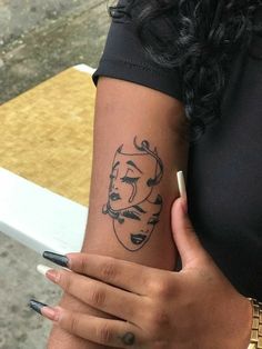 a woman with a face tattoo on her arm