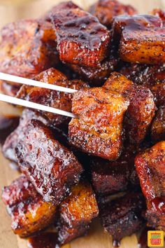 barbecued meat with bbq sauce and tongs on a cutting board, ready to be eaten